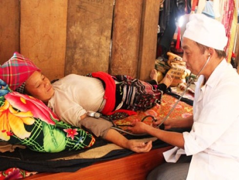 Dr Hang A Ho examines a patient in Pu Sam Cap Commune in the northern mountains. The health sector should adopt favored treatment for medical staffs who work in imporverished areas (Photo: Tuoi Tre)